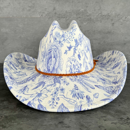 Cowboy hat with blue floral pattern on a gray background