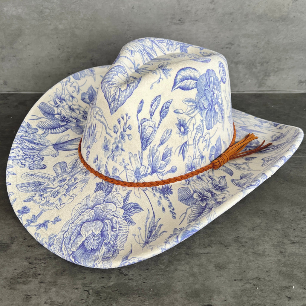 Cowboy hat with blue floral pattern on a gray surface