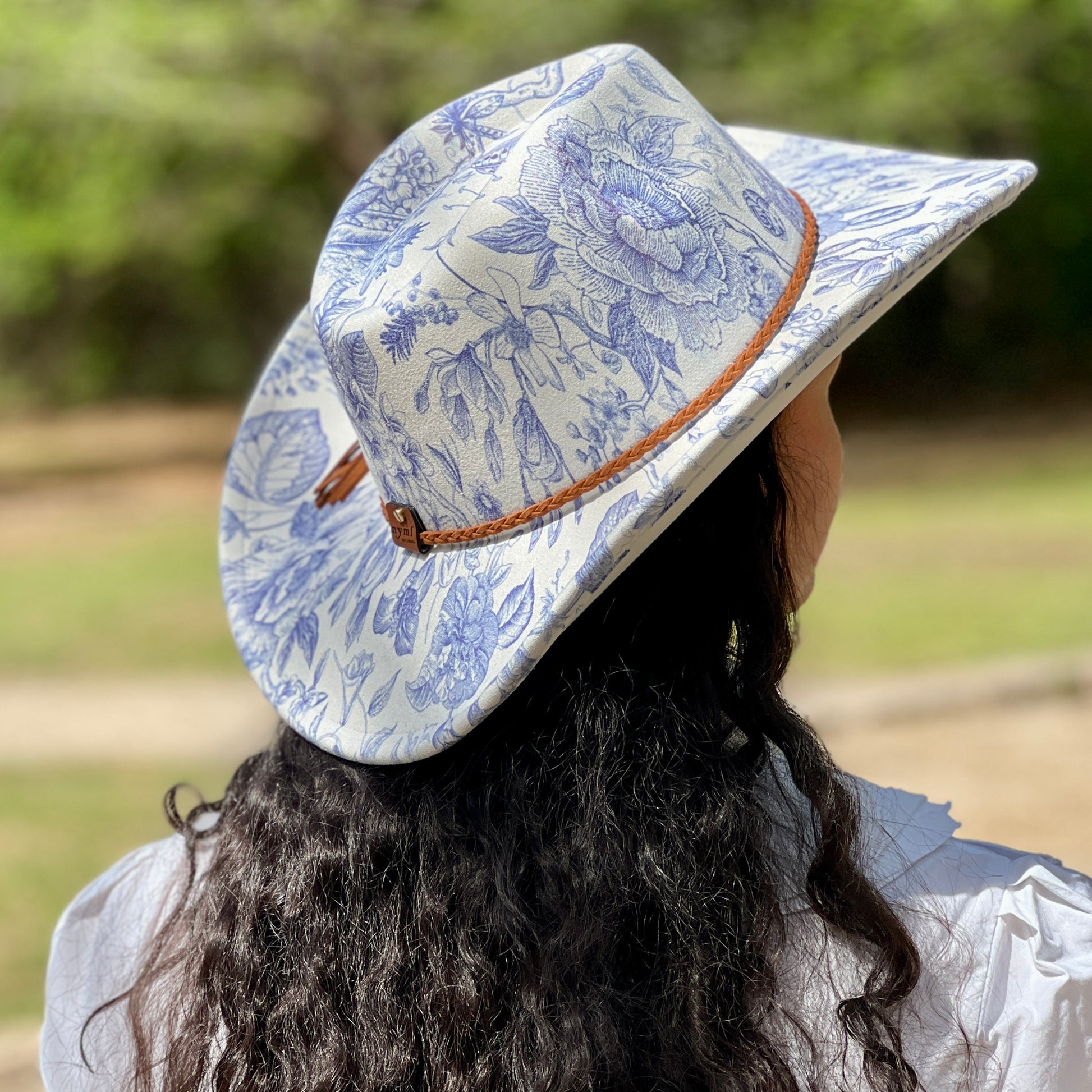 Person wearing a blue floral-patterned hat outdoors