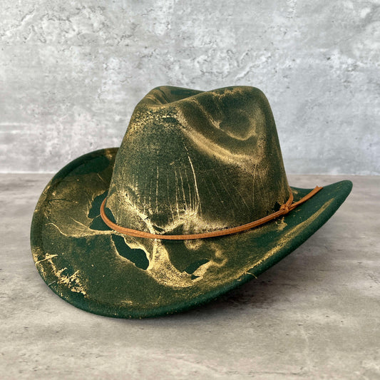 Forest green western cowboy hat painted with gold marbling. Has light brown faux suede cord hat band. 