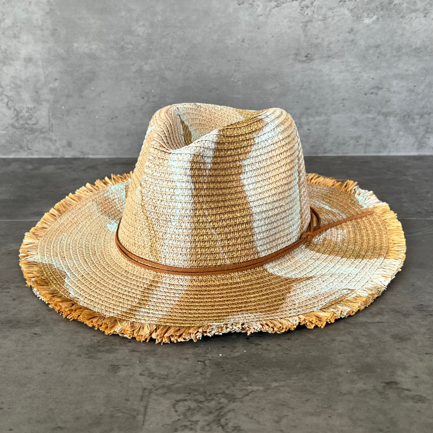 front view of tan khaki straw brim rancher hat with fringe has seafoam mint and gold paint marbling  and brown leather faux suede cord. sun hat.