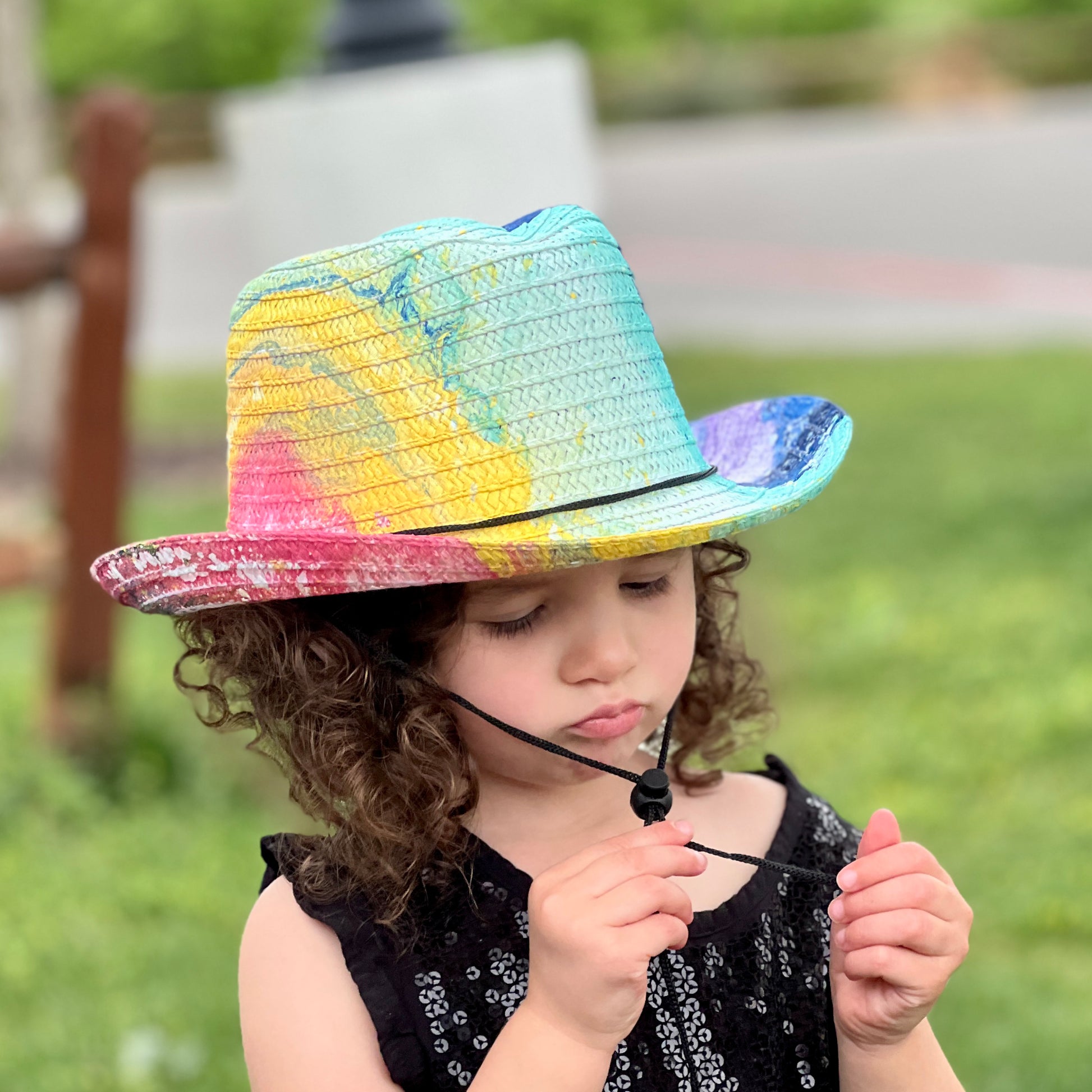 Child wearing a colorful hat in an outdoor setting
