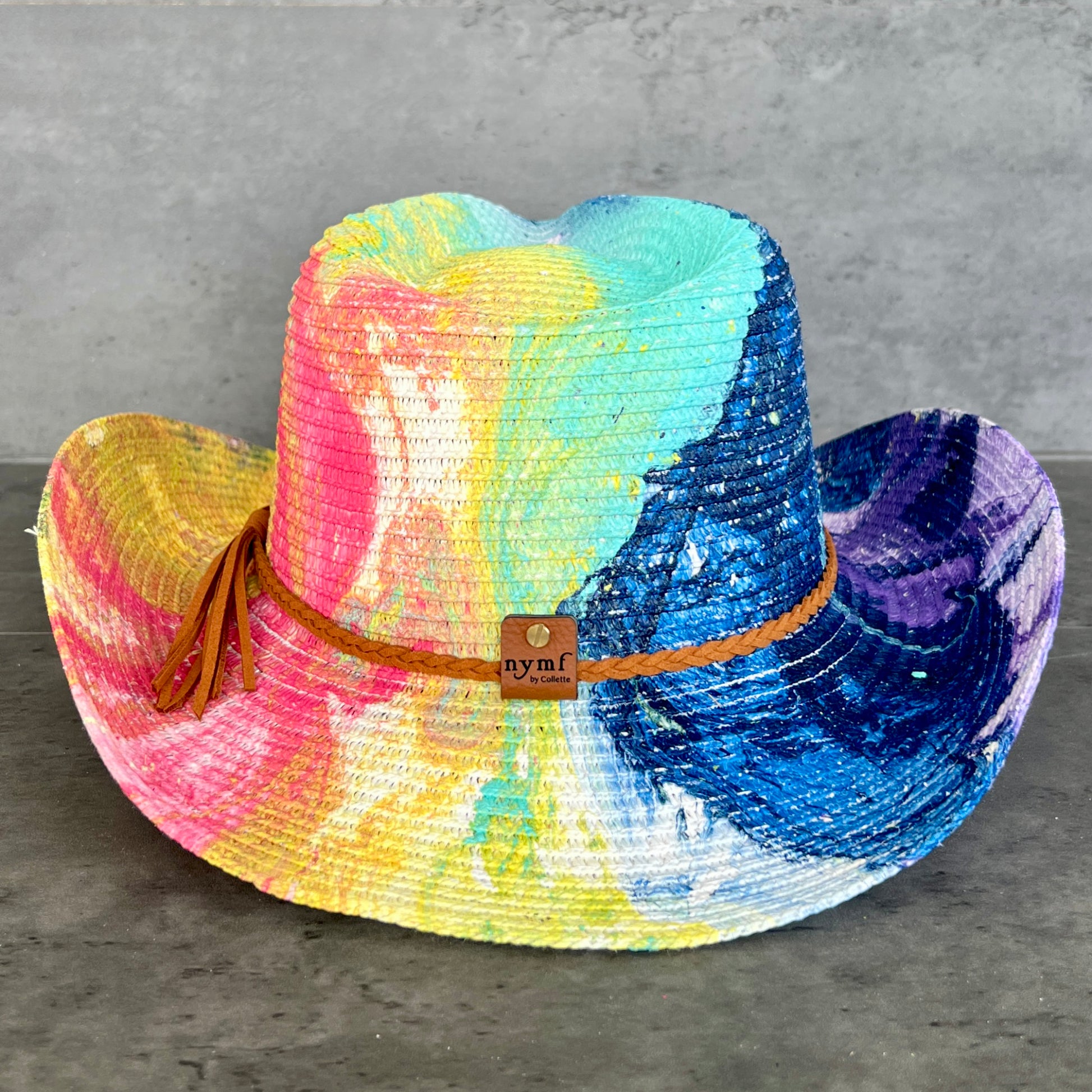 Colorful straw cowboy hat on a gray surface