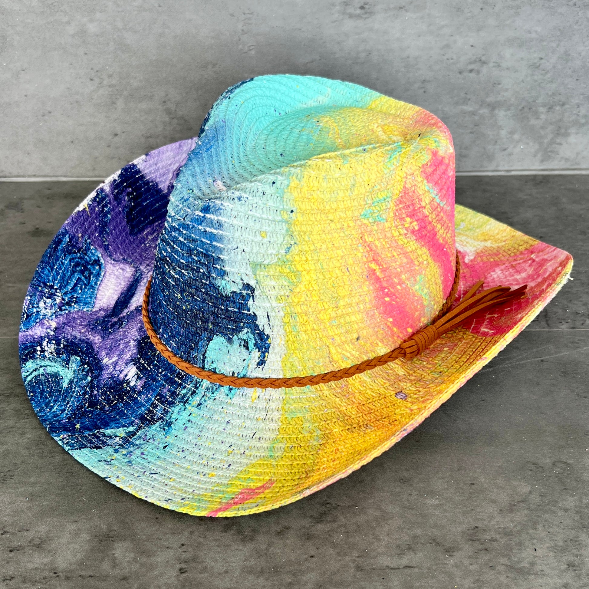 Colorful straw hat with a brown band on a gray surface