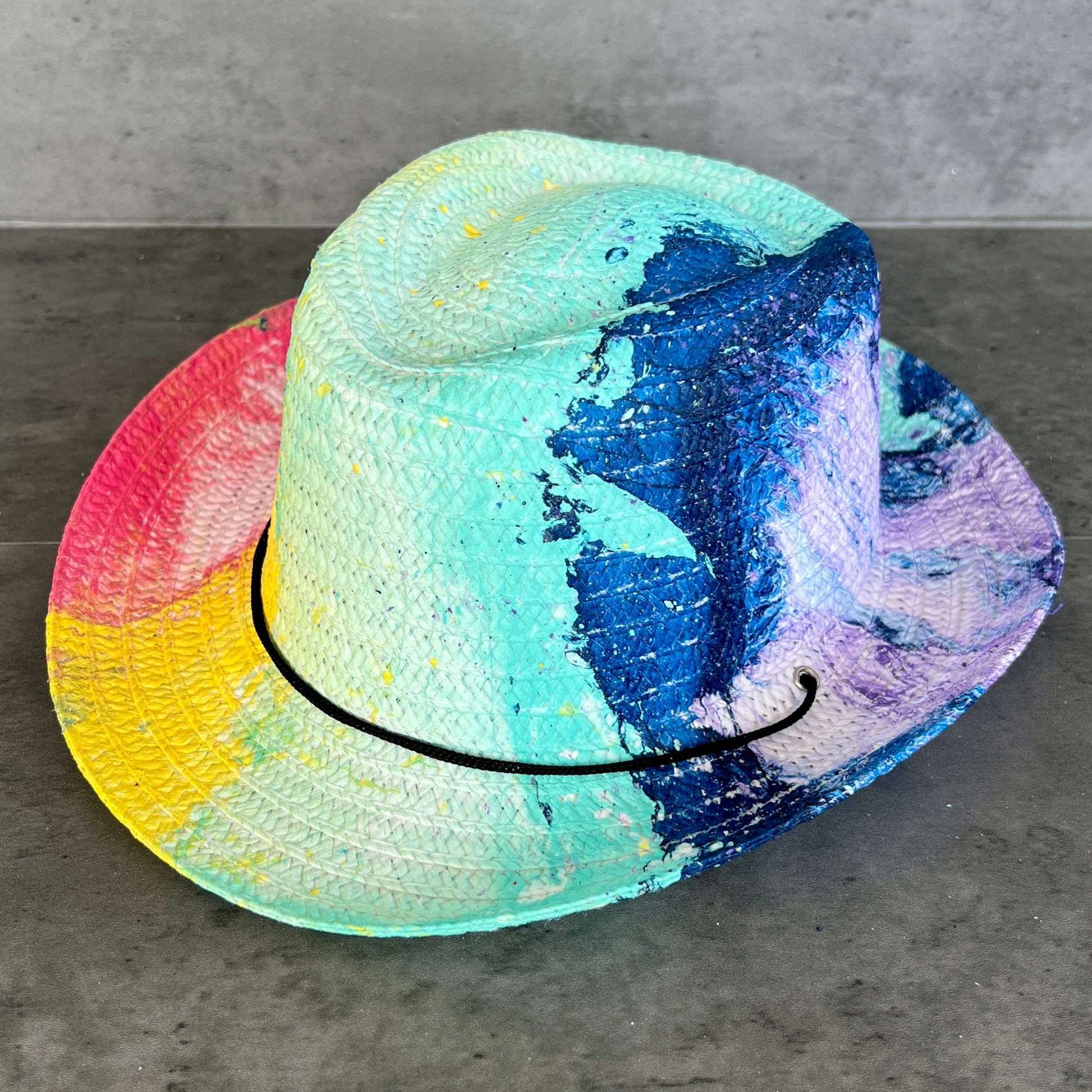 Colorful straw hat on a gray surface