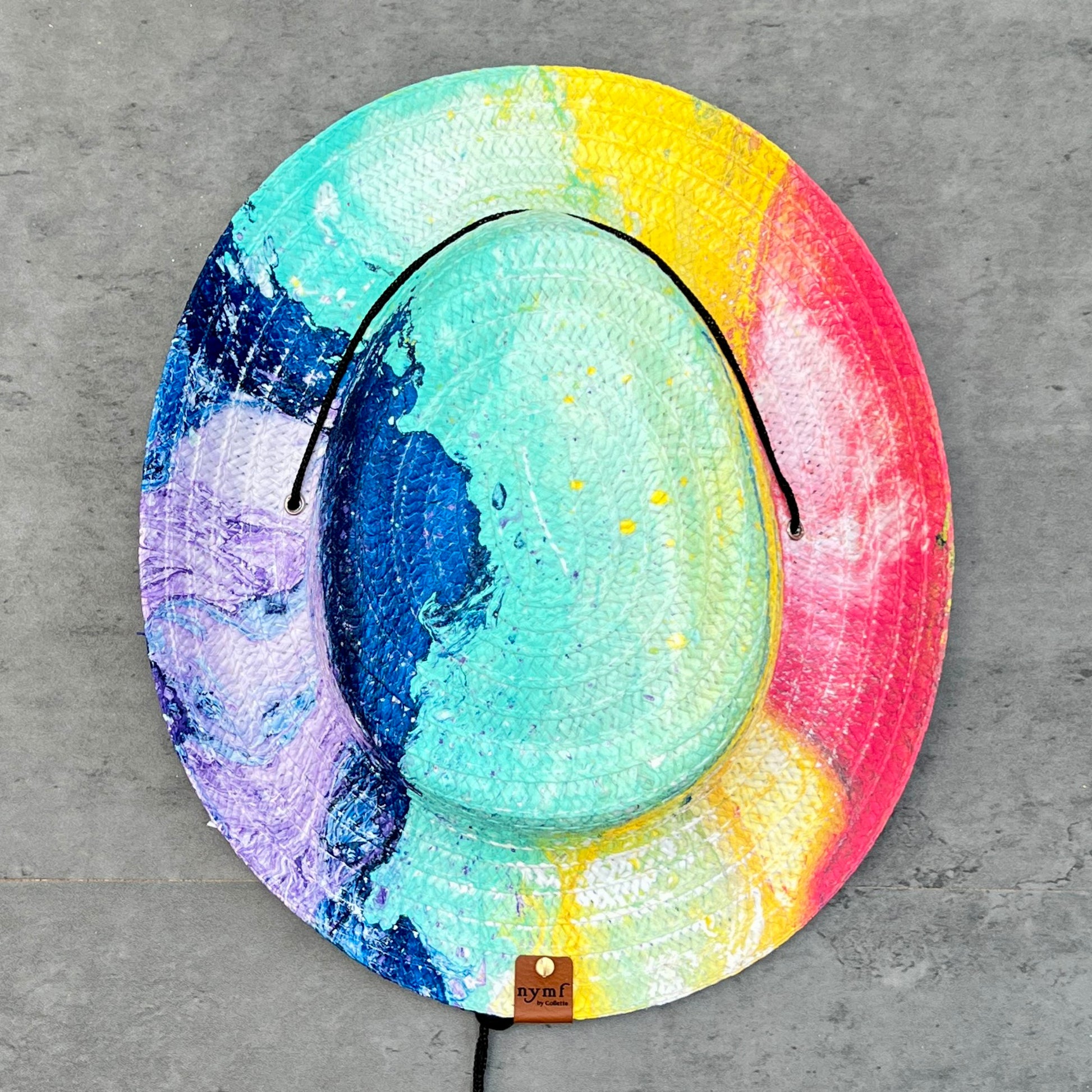 Colorful hat with a gradient from blue to pink on a gray surface