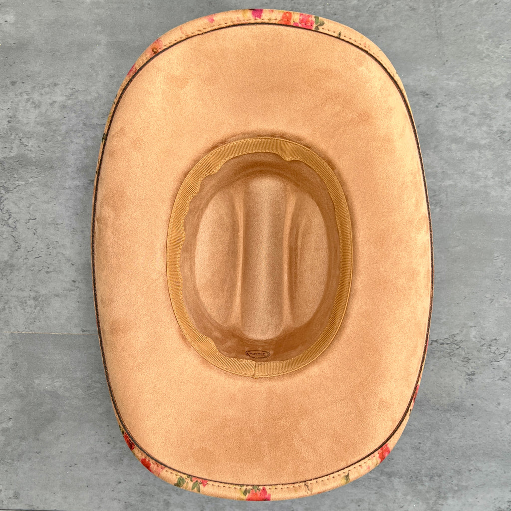 Tan suede hat base placed on a gray textured surface.