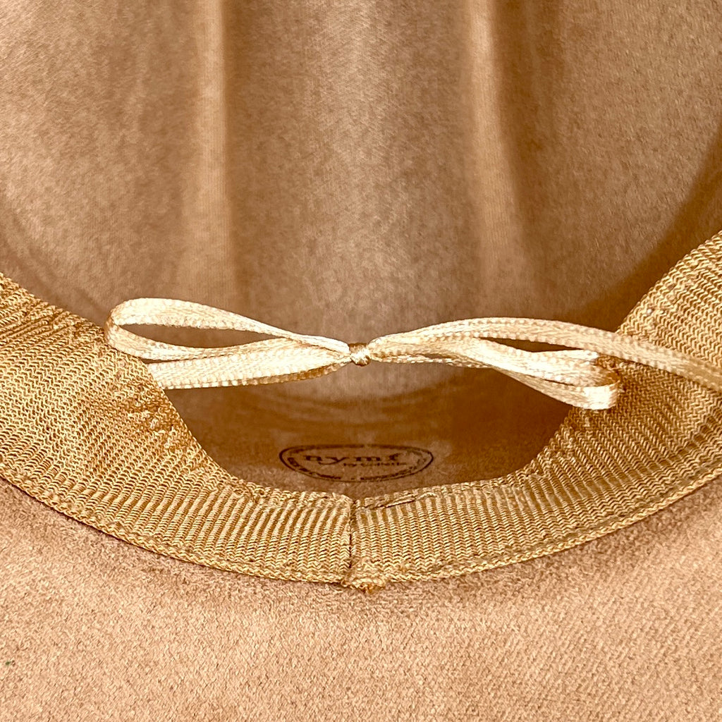 Close-up of a tan hat interior showing a ribbed fabric band with a cream ribbon bow