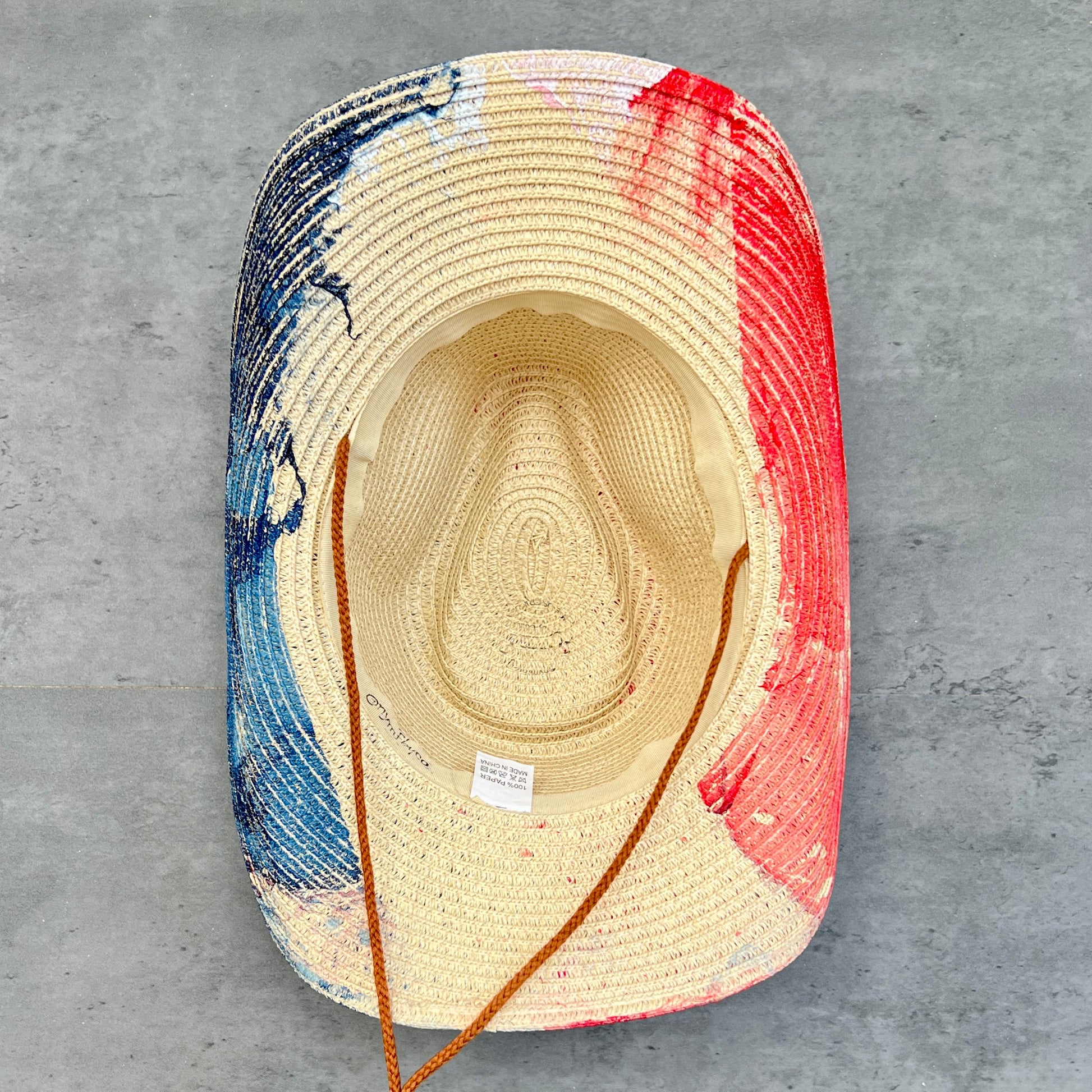 Colorful straw hat with a textured pattern on a gray surface