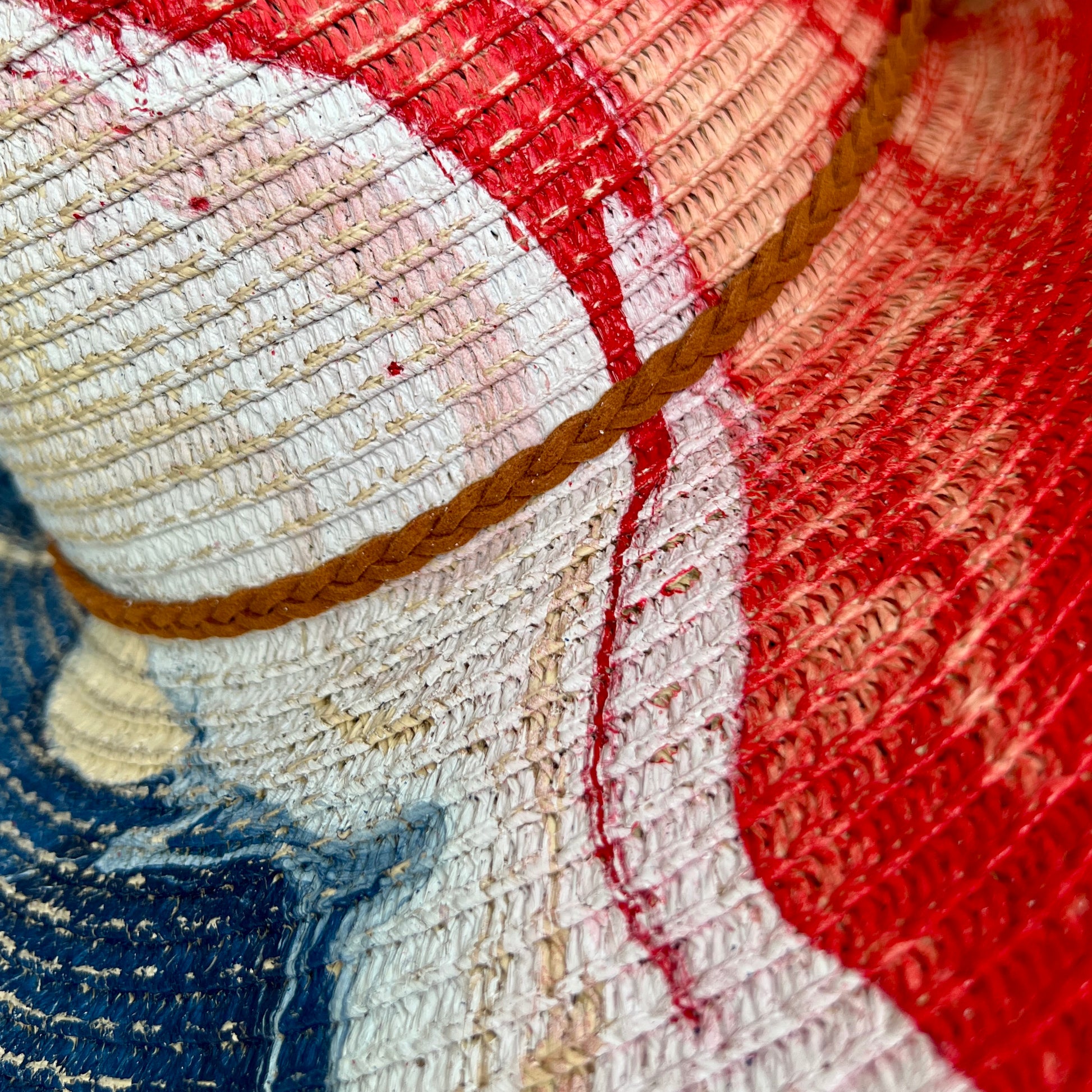Close-up of painted straw hat with red, white, and blue colors