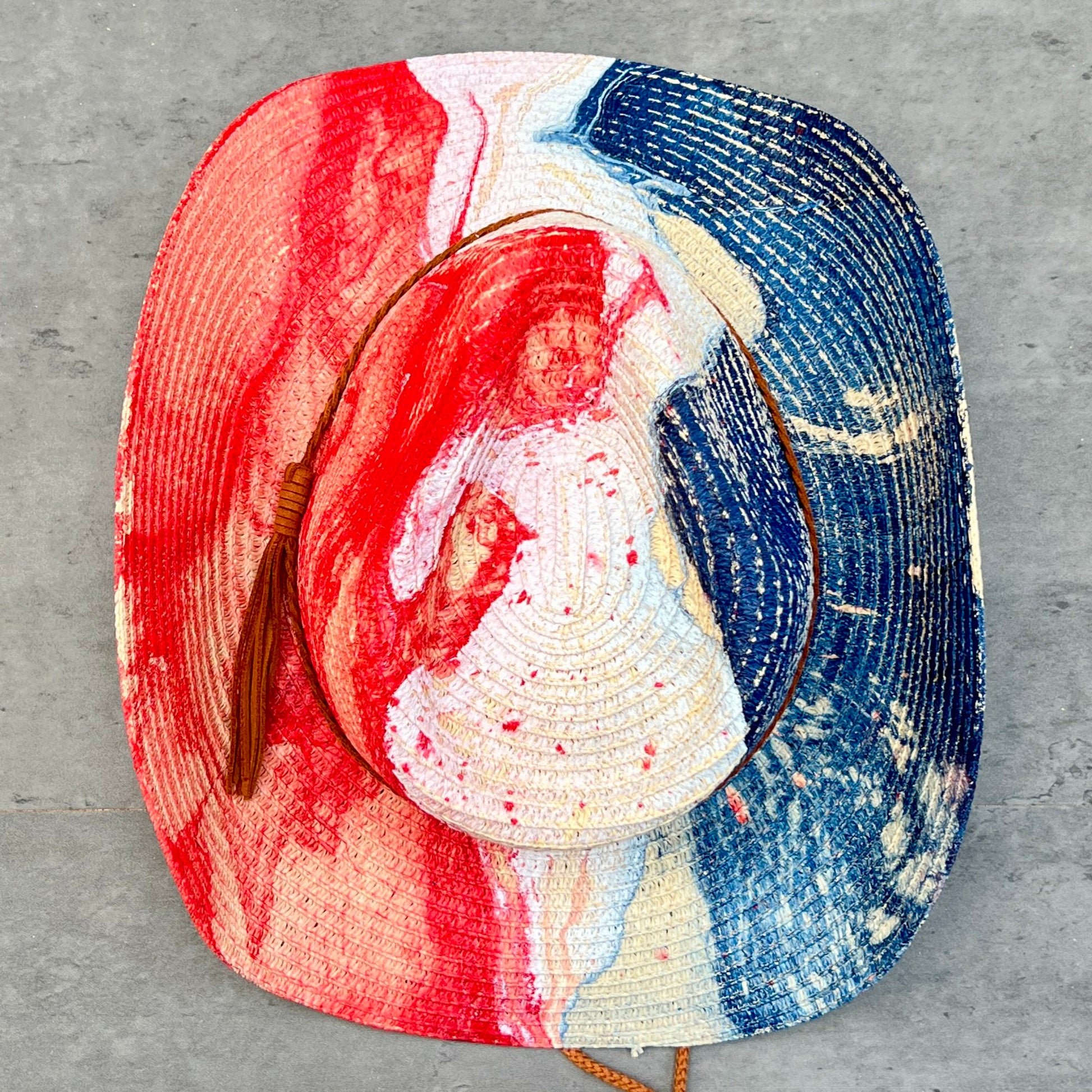 Colorful woven hat with red, white, and blue design on a gray surface