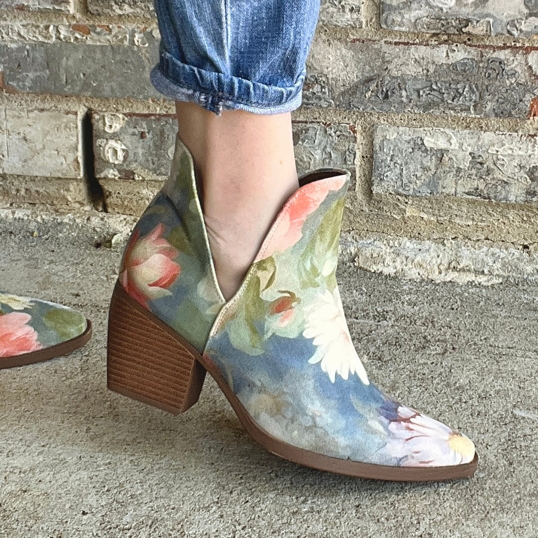 Woman wearing blue floral Western-inspired ankle boots with jeans