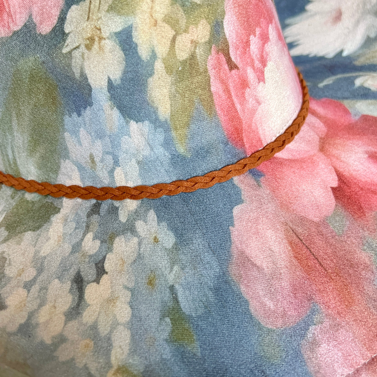 Close-up of painterly floral pattern on blue cowboy hat