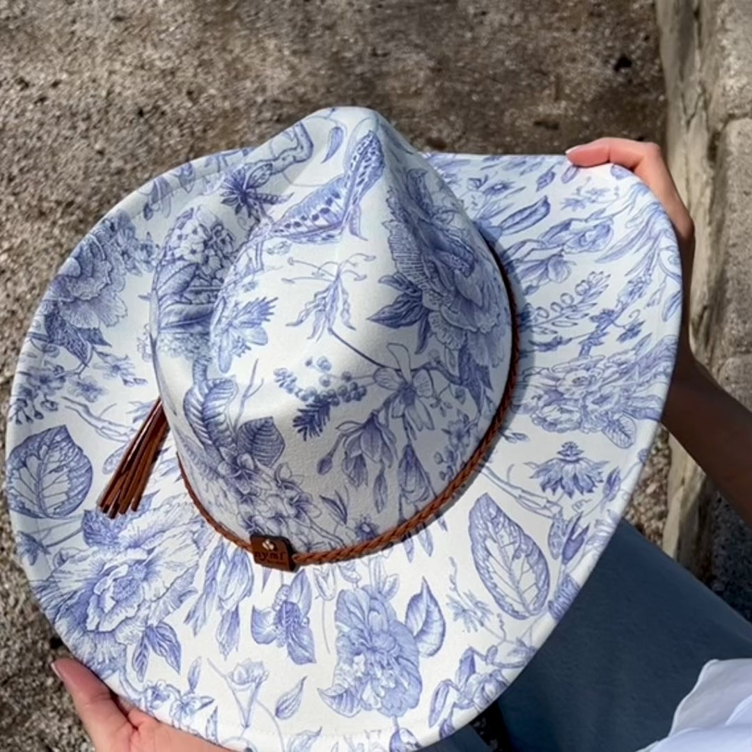 video showing white hat with blue florals on model